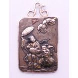 A 19th century Japanese pendant/plaque depicting figures in a storm, worked in gold,