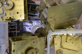 A box of various brass clock movements including a longcase movement and a fusee movement.