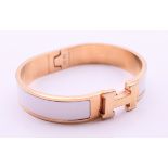 A Hermes Paris white enamel gold plated Clic H bracelet, in a Hermes box. 6.