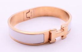A Hermes Paris white enamel gold plated Clic H bracelet, in a Hermes box. 6.
