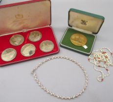 Set of silver plated commemorative Silver Jubilee coins, a yellow commemorative coin and two