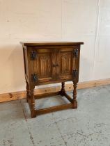 Small oak bedside cabinet with two linenfold panel doors on baluster turned supports with