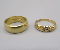 18ct yellow gold wedding band, size L1/2, and an 18ct yellow gold ring set with a row of three