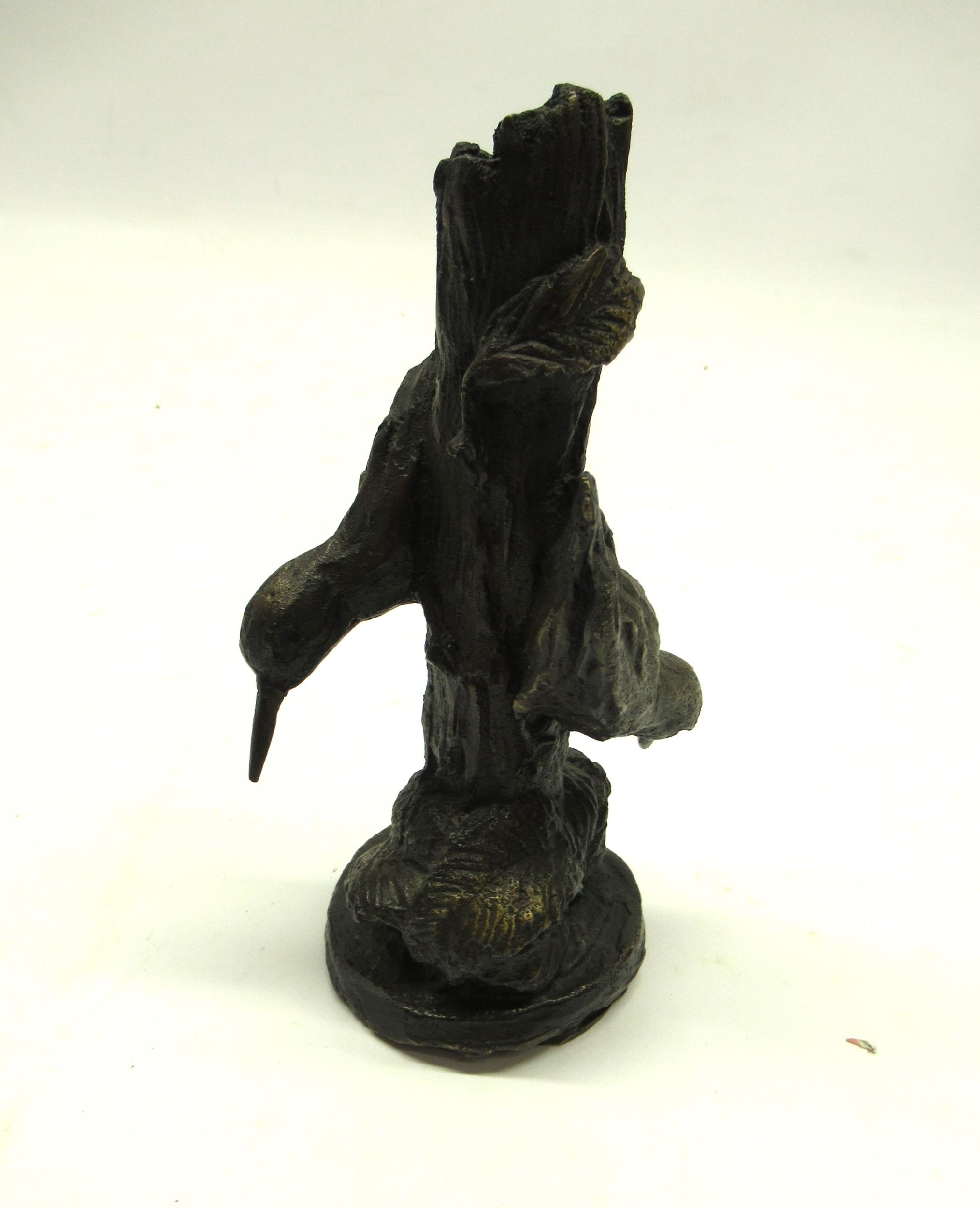 Bronze sculpture in the form of a tree stump with two green woodpeckers and foliage, base stamped