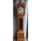 C20th light oak long cased clock, arched dial above glazed door on panel base with bracket feet,