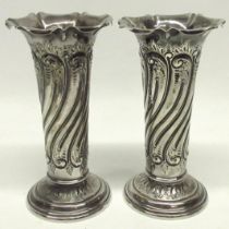Late Victorian silver vases, pillar form decorated with scrolling patterns and a flared opening,
