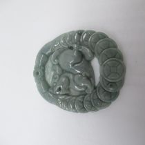 Jade carved pendant with Foo dog surrounded by shield border, with certificate of identification