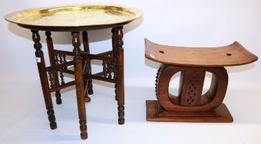 African ashanti type stool, H37cm; and a Middle Eastern style circular brass topped table with