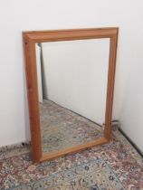 Wall mirror with upright bevelled plate in waxed pine cushion frame, H88cm W63cm