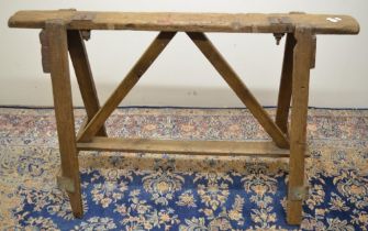 C20th wooden saw horse or trestle, plain top with two adjustable screw clamps, on out splayed