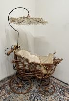 Victorian style metal framed dolls pram with upholstered cane work cradle and lace parasol, H110cm