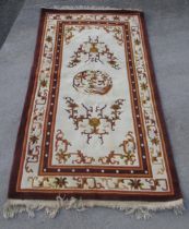 C20th Chinese embossed washed wool rug, cream ground with central medallion and stylised repeating
