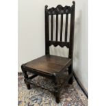 C18th oak back stool with scroll carved cresting and solid seat on turned supports