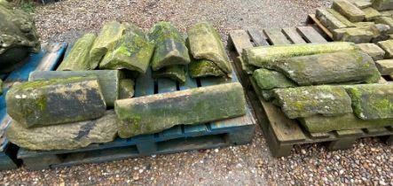 Two pallets containing a quantity of sandstone ridge tiles in various conditions