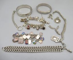 Two hallmarked sterling silver bangles, two silver fob charms, a silver enamel travel charm bracelet