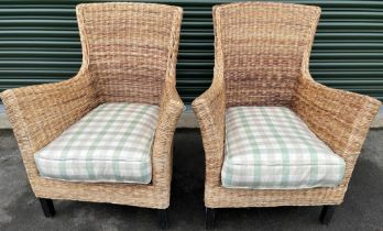 Pair of rattan conservatory chairs with shaped backs and outsplayed arms on square supports, loose