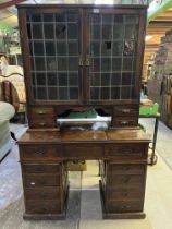 Edwardian oak kneehole writing cabinet, two lead coloured glass doors above hinged writing service