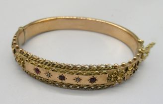 9ct yellow gold ornate hinged bangle set with three red stones and two diamonds in star cut