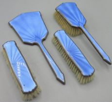 Four Piece Art Deco blue enamel and silver dressing table set incl. three brushes and a hand mirror,