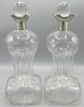 Pair of Edwardian silver mounted clear glass glug-glug decanters and stoppers, with silver four