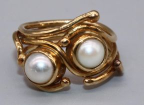 Yellow metal ring by Susan Wright, set with two pearls in open abstract wirework band, no visible