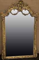 Large Rococo Revival gilt wall mirror, upright plate in C scroll moulded frame with swag and shell