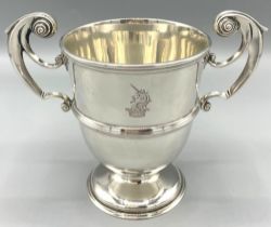 Edwardian silver loving cup, plain body with reeded band and scroll handles on stepped circular