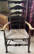 Early 19th century ash and elm Lancashire ladderback elbow chair, with shaped top rail, flattened