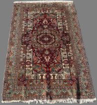 20th century Persian red ground wool rug, central floral medallion field, in repeating stylised