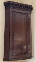 George III oak corner cupboard, with Greek Key cornice and blind fret frieze above a raised and