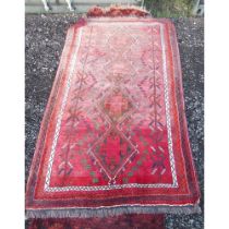 Caucasian red ground multicoloured rug, with quadruple hooked lozenge medallion field in repeating