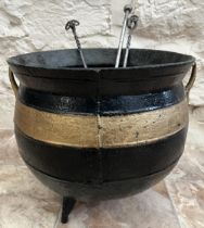 Cast iron cauldron, with two handles and on three feet, later black painted with gold band, D37cm