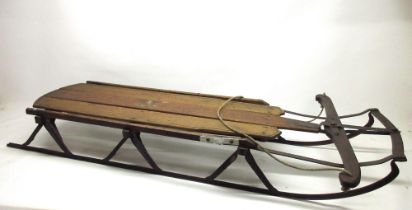 'Flexible Flyer' articulated sledge, stained oak and cast iron, L151cm