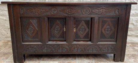 18th century oak coffer with later fixed planked top, frieze carved with lozenge, rose and