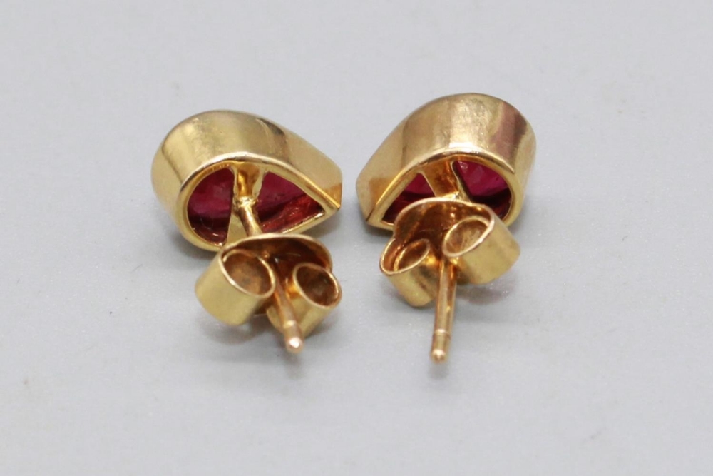 Pair of yellow metal ruby earrings, the teardrop cut rubies in rub over settings, one back stamped - Image 2 of 2
