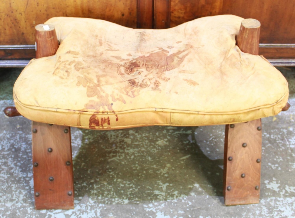 20th century camel saddle, dished seat and leather cushion on curved supports, W68cm