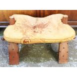 20th century camel saddle, dished seat and leather cushion on curved supports, W68cm