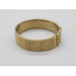 9ct yellow gold hinged bangle, with half foliage engraved detail, stamped 375, with inner