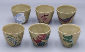 Moorcroft Pottery: set of six sake cups, each with varying tubelined decoration, green ground, H4.