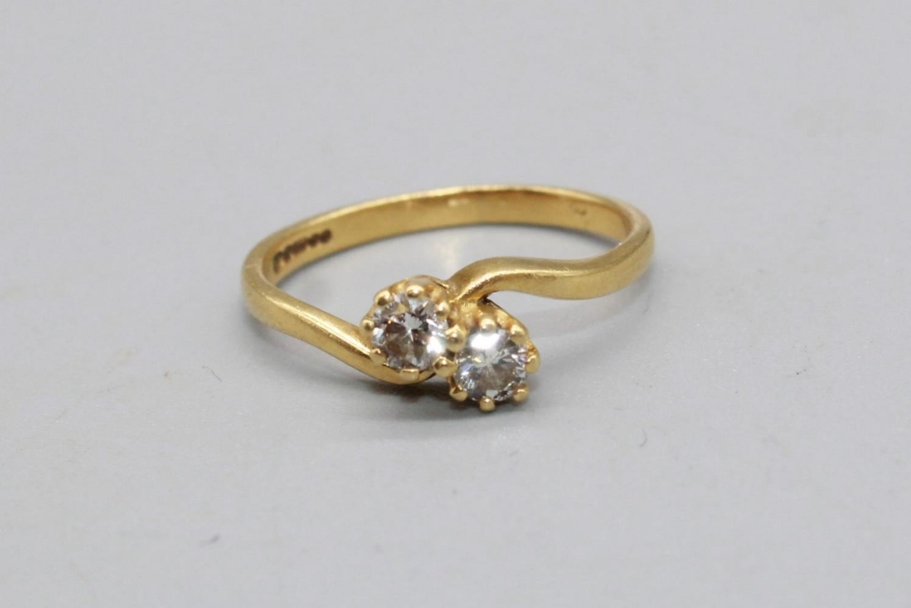 18ct yellow gold diamond cross over ring, set with two brilliant cut diamonds, stamped 750, size