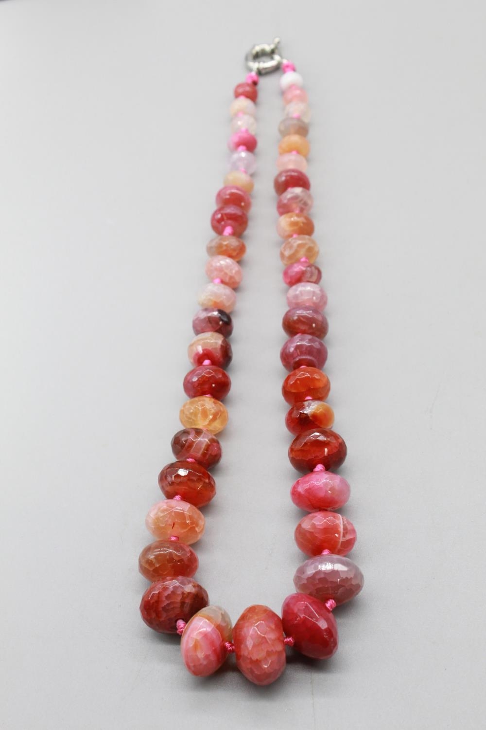 Pink cut stone necklace set with cut agate, quartz etc. on pink double-knotted thread, with white