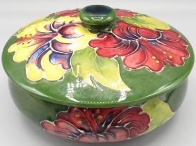 Moorcroft Pottery: 'Hibiscus' pattern circular trinket pot and cover, purple and yellow flowers on