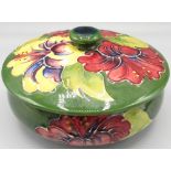 Moorcroft Pottery: 'Hibiscus' pattern circular trinket pot and cover, purple and yellow flowers on