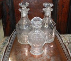 Pair of mallet shaped decanters etched with trees, one cracked, another smaller decanter, and an