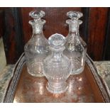 Pair of mallet shaped decanters etched with trees, one cracked, another smaller decanter, and an