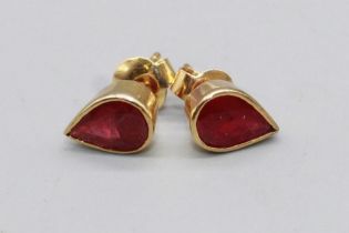 Pair of yellow metal ruby earrings, the teardrop cut rubies in rub over settings, one back stamped