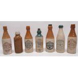 Collection of early 20th century stoneware ginger beer bottles, predominantly Scottish, one of
