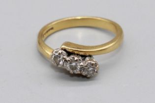 18ct yellow gold cross over three stone diamond ring, the diamonds illusion set, stamped 750, size