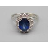 18ct white gold sapphire and diamond cluster ring, the central oval cut sapphire surrounded by a