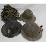 A collection of four military helmets, comprising two Mk II Brodie helmets, a WW2 Warden's helmet,